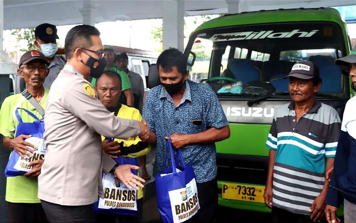 Sopir angkot di Terminal Bus Bondowoso menerima bansos paket sembako dari Polres Bondowoso. (Foto: Guido Saphan/Ngopibareng.id)