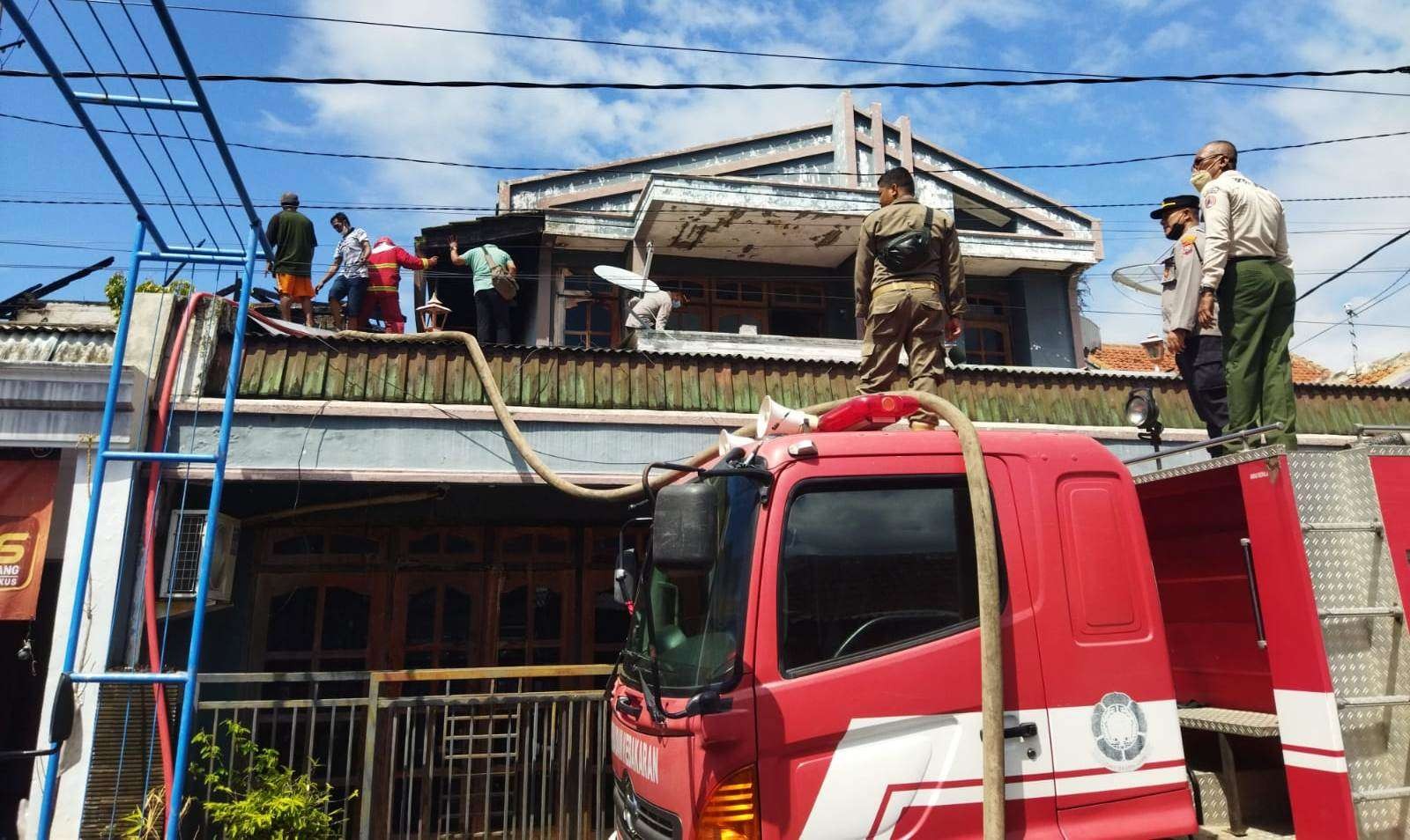 Petugas pemadam kebakaran berupaya memadamkan api di rumah warga (Foto:istimewa)