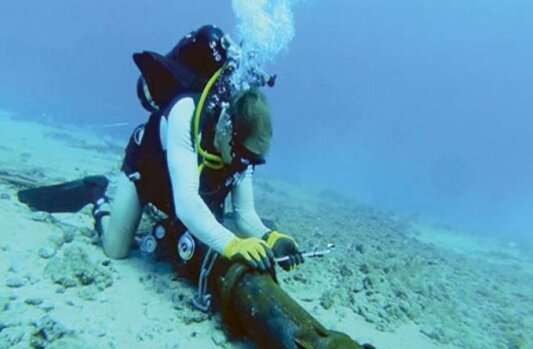 Seorang petugas meletakkan kabel bawah laut.(Foto: mitech)