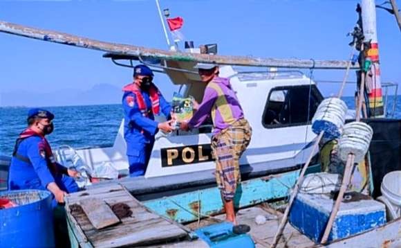 Anggota Satpolair Polres Situbondo mendatangi langsung nelayan sedang melaut membagikan paket sembako. (Foto: Humas Polres Situbondo)