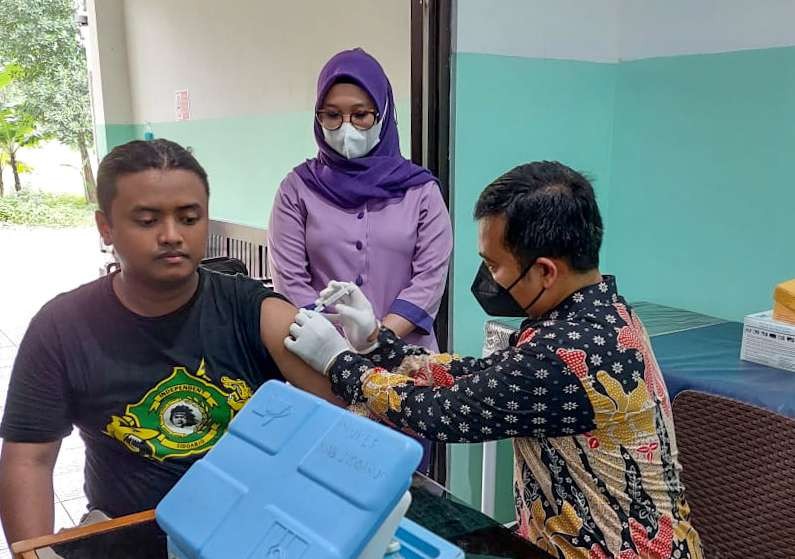 Dokter Andre Yulius saat memberi suntikan vaksin kepada warga (foto : Aini/Ngopibareng.id)