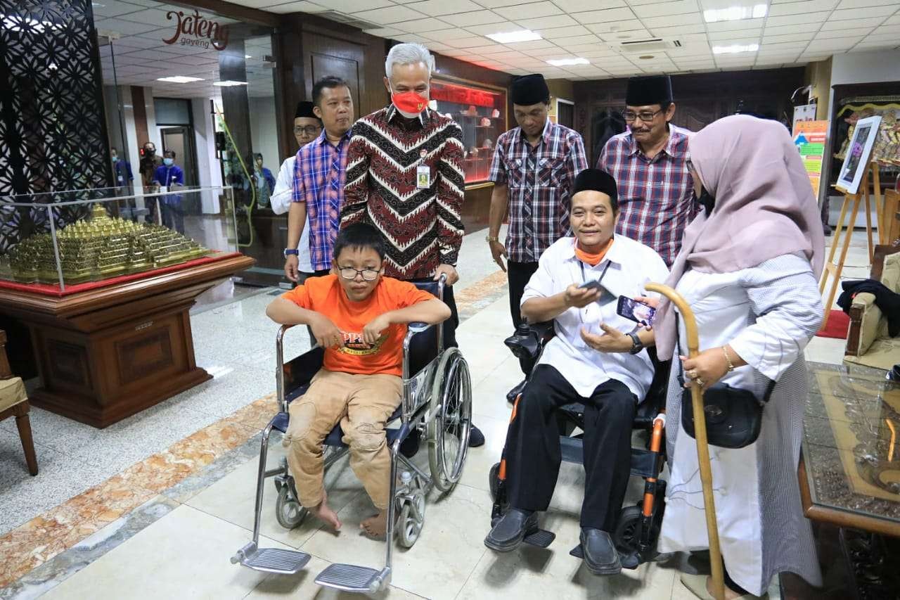 i Gubernur Jawa Tengah Ganjar Pranowo bersama Kholilur Rohman (kiri). Kholilur Rohman mendapat kursi roda elektrik karena rajin mengaji. (Foto: istimewa)