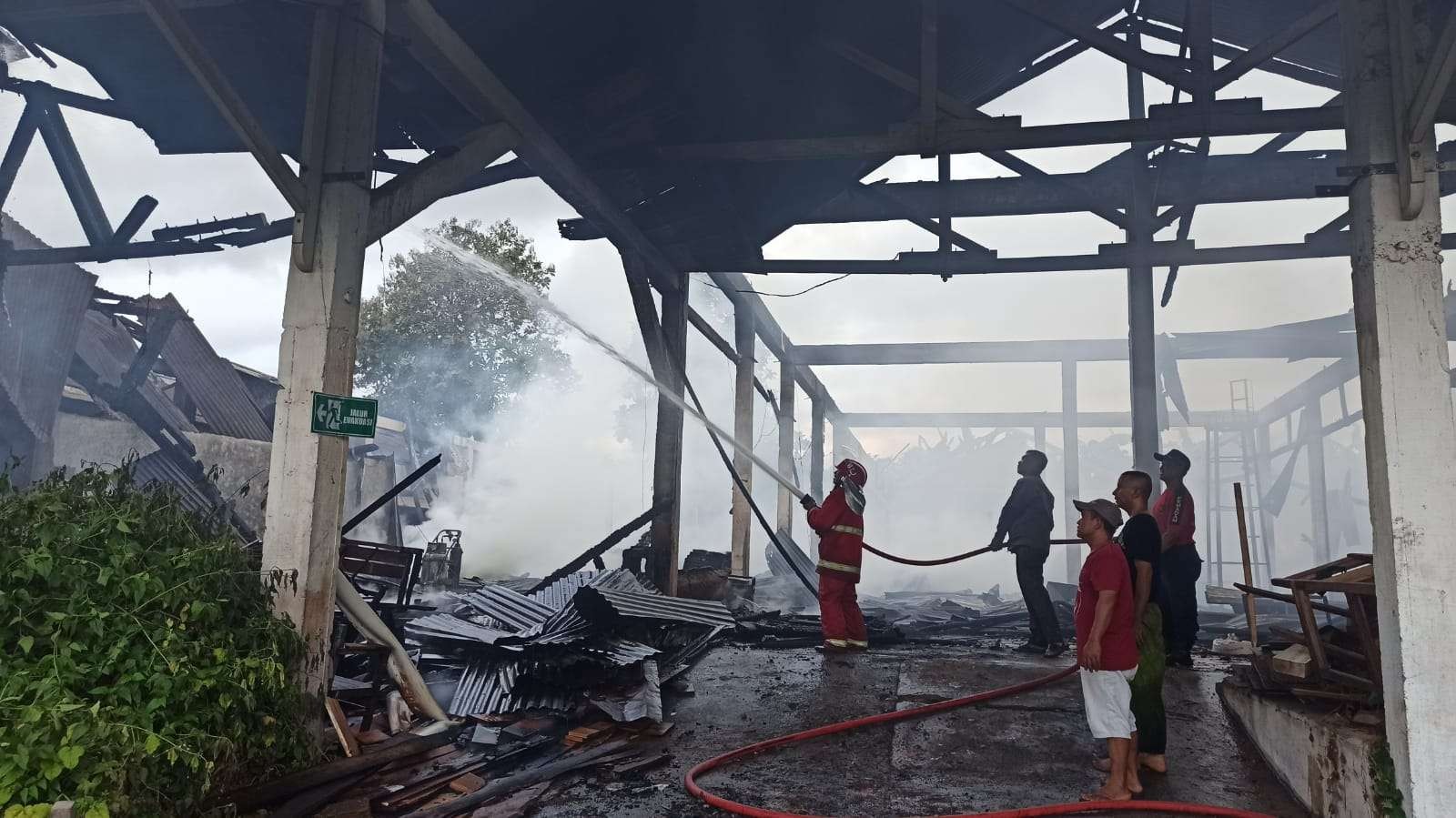 Petugas Pemadam Kebakaran berusaha memadamkan api kayu di perusahaan mebel. (Foto: Muh Hujaini/Ngopibareng.id)