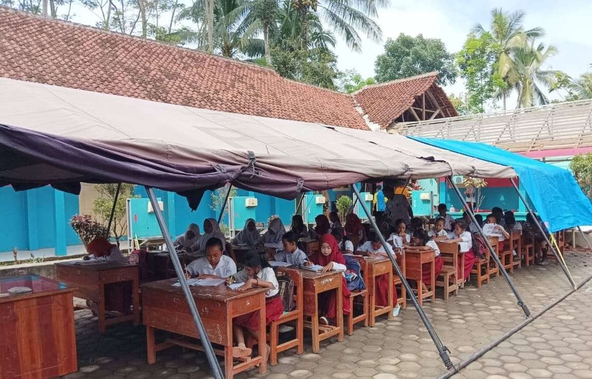 175 siswa SDN Gelang 7 Kecamatan Sumberbaru, Jember belajar di bawah tenda pasca ruang kelas mereka ambruk (Foto: Rusdi/Ngopibareng.id)