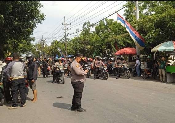 Massa pesilat sedang berkumpul di Jalan Soemargo, Lamongan dikawal polisi (Foto: Imron Rosidi/Ngopibareng.id)