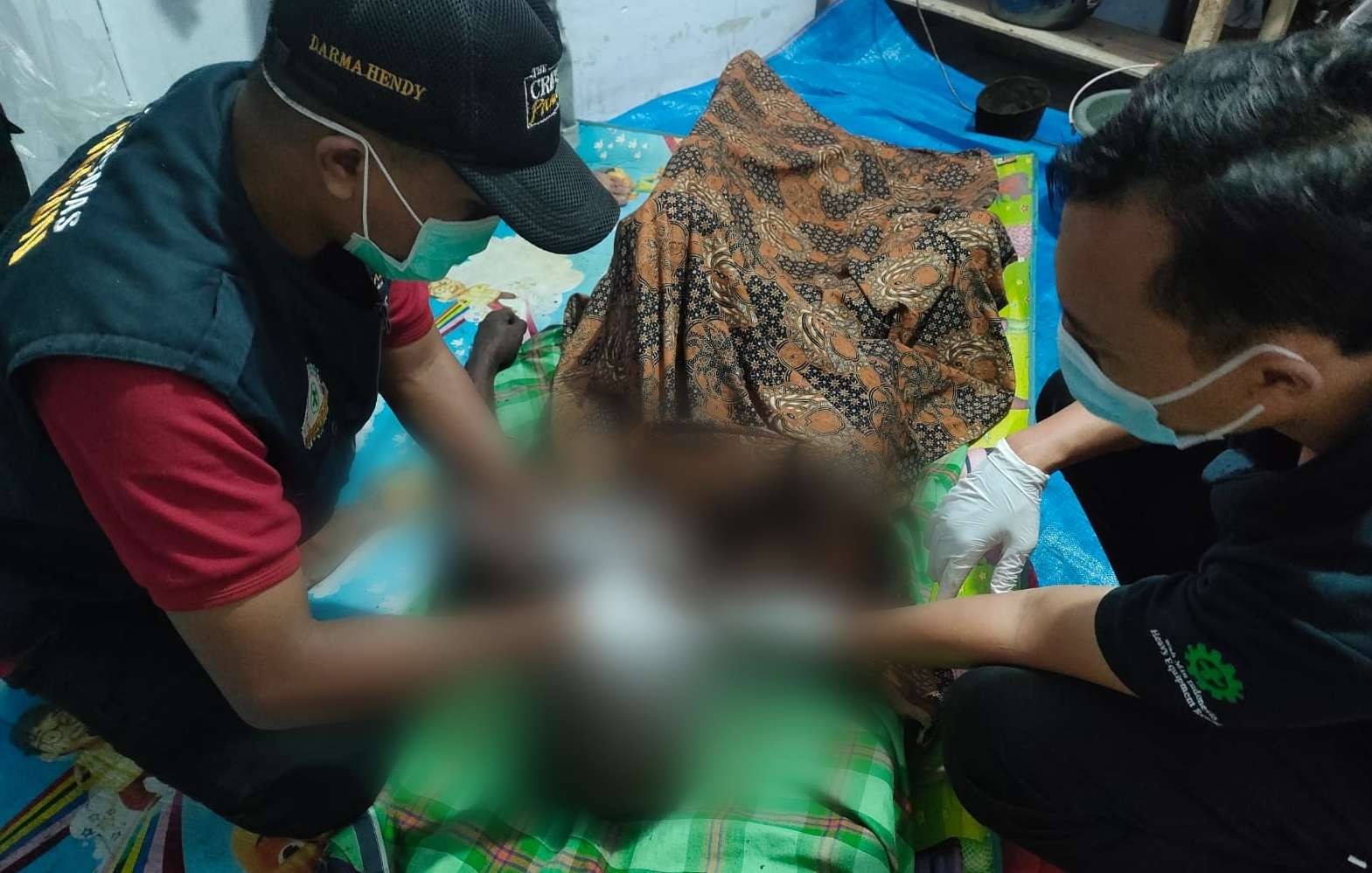 Petugas medis memeriksa kondisi kakek Nh yang terbakar di dalam kamarnya (Foto: Istimewa)