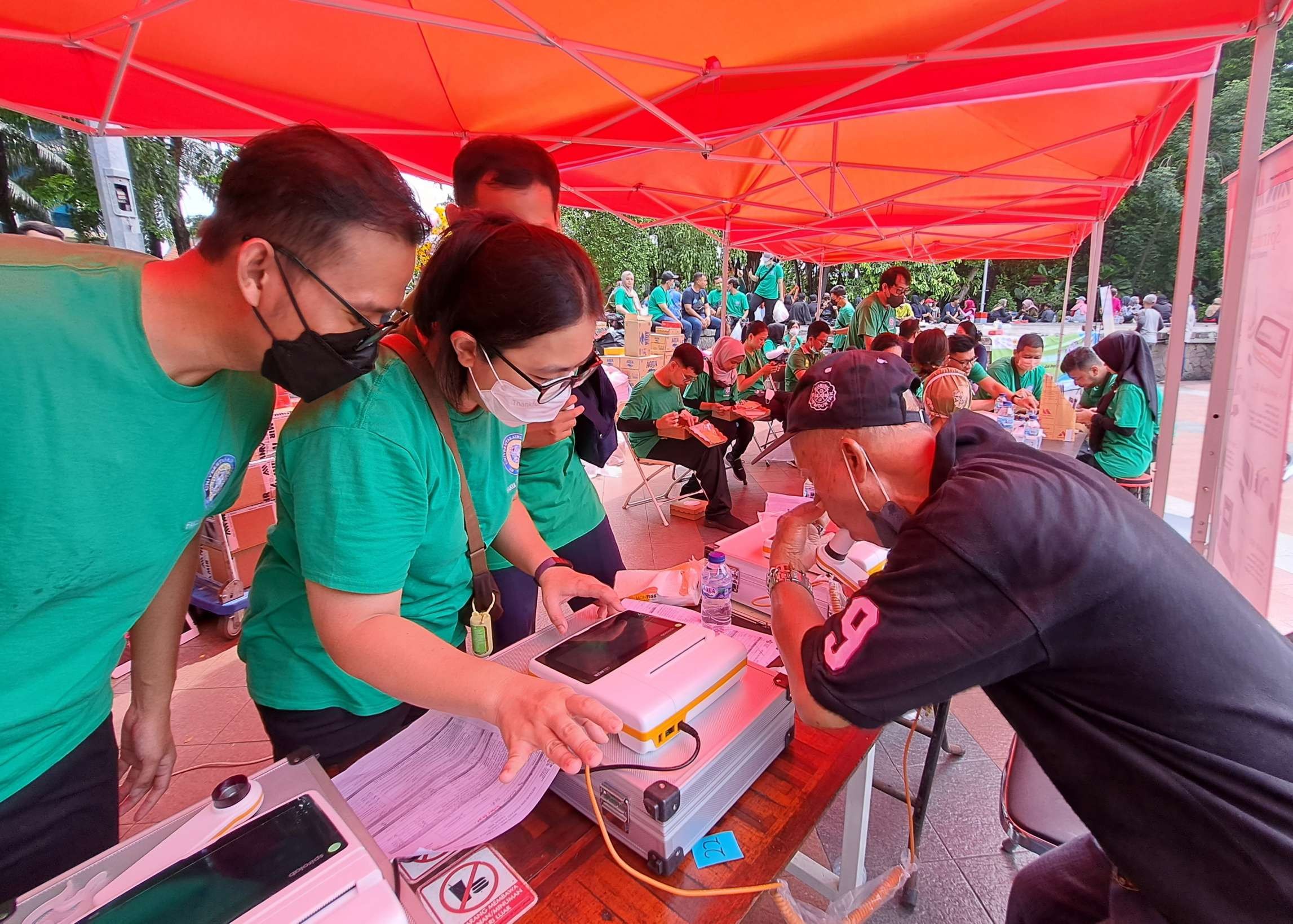 Hartoyo, salah satu pengunjung Taman Bungkul yang sedang melakukan pemeriksaan dengan alat spirometer dalam layanan kesehatan yang dibuka dokter spesialis paru FK Unair. (Foto: Pita Sari/Ngopibareng.id)