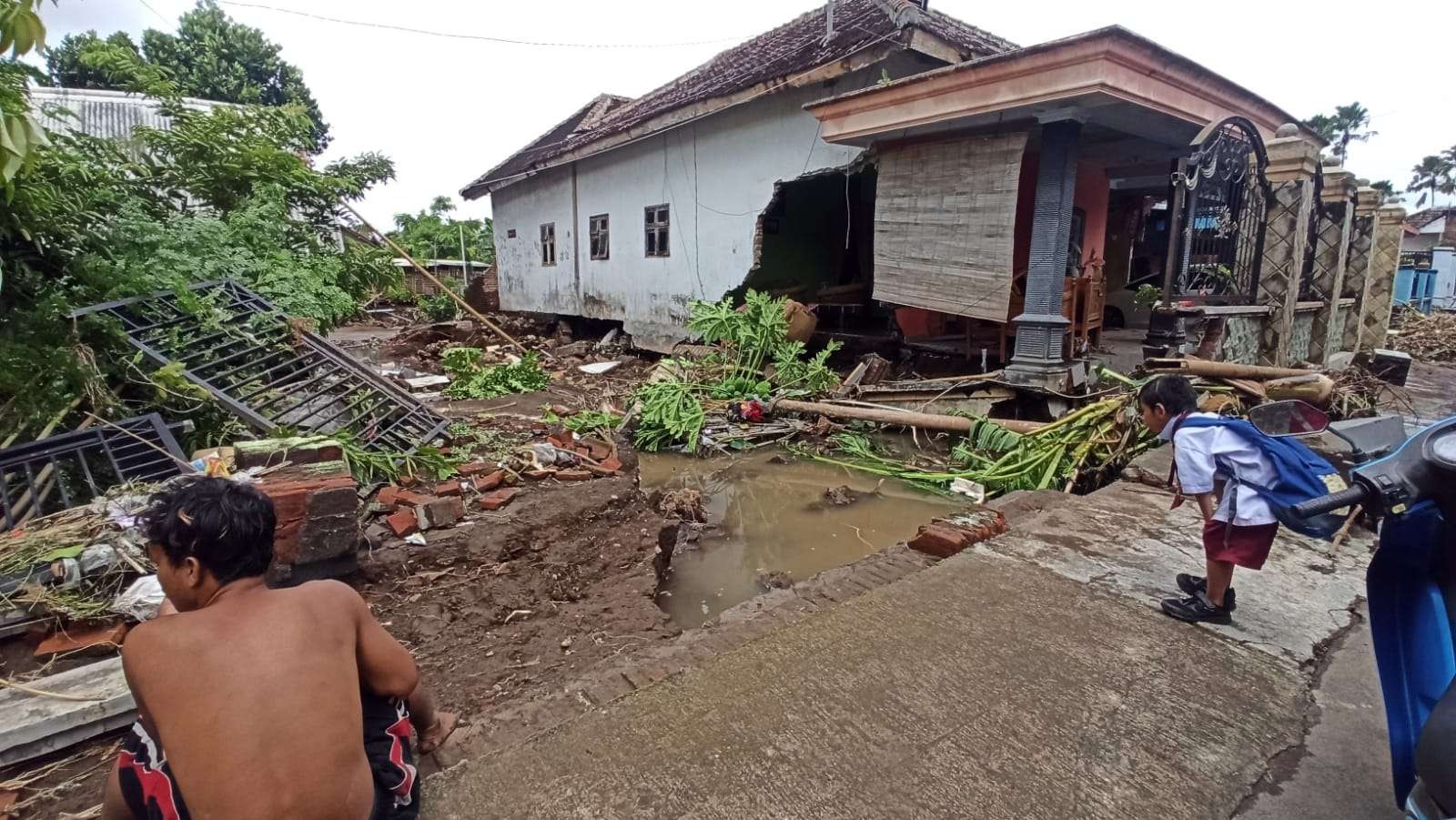 Salah satu tembok rumah warga jebol akibat terjangan luapan air sungai Kali Sobo (Foto: Muh Hujaini/Ngopibareng.id)