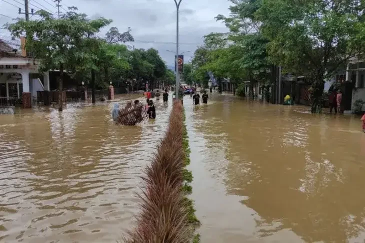 Sejumlah warga saat proses evakuasi banjir yang merendam jalan raya Soekarbo-Hatta Trenggalek, Selasa 18 Oktober 2022. (Foto: Antara)