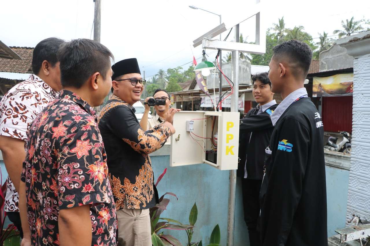 Kades Sidomulyo (berpeci) didampingi Dekan FT dan M Ali Yafi (kanan) memeriksa alat Wireless Sensor Network (WSN) yang ditempatkan di halaman balai desa setempat (Foto: Dok Humas Unej)