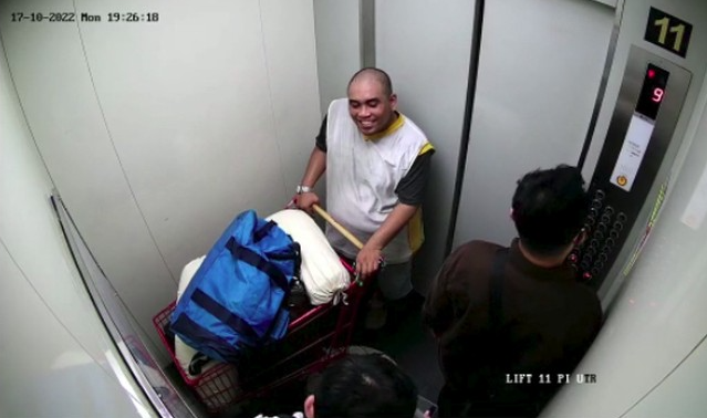 Rudolf Tobing terekam CCTV lift sebuah apartemen. Ia tampak tersenyum saat membawa troli berisi jasad Icha. (Foto: CCTV)
