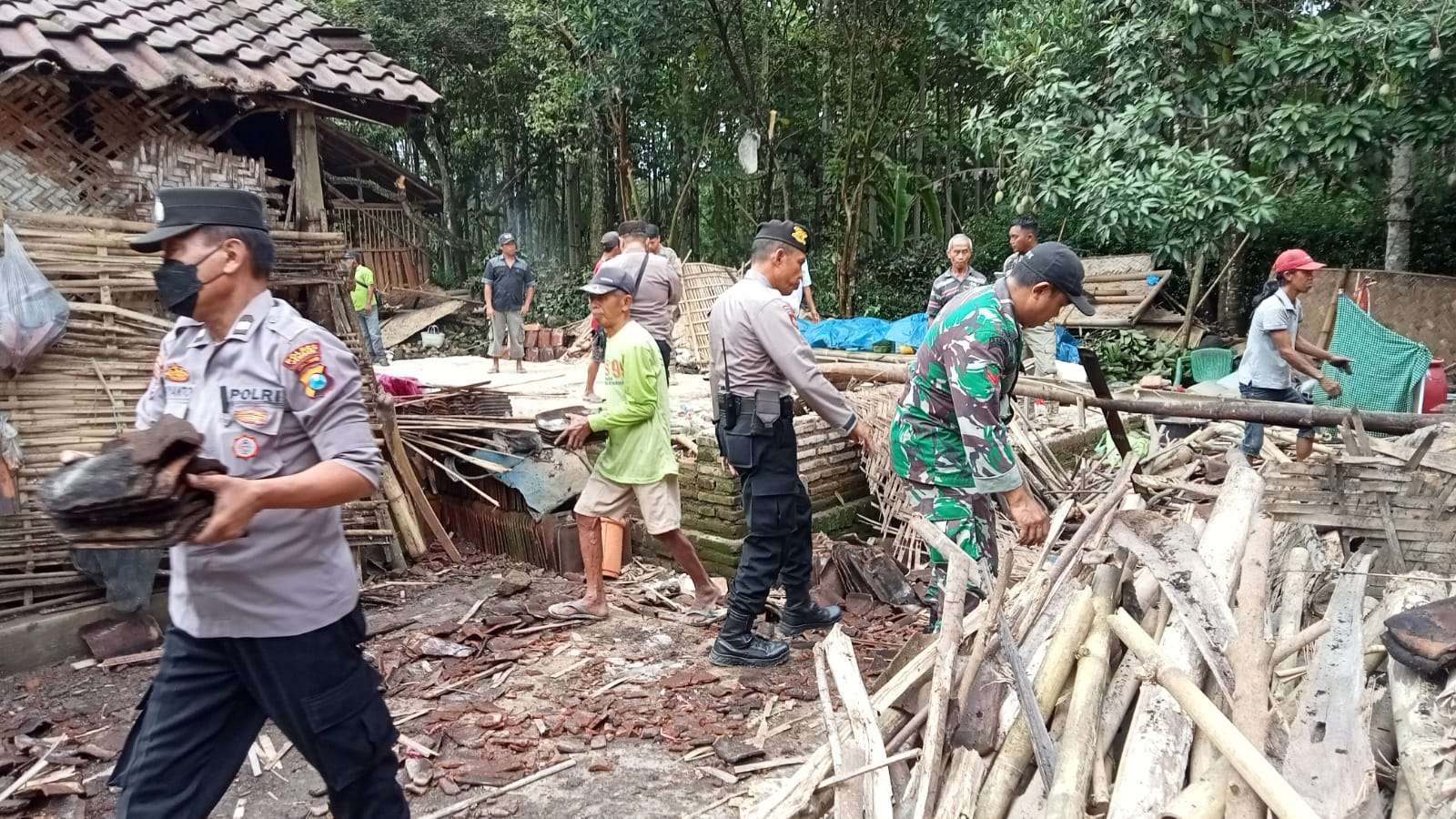 Polisi dan TNI bersama warga sedang membantu membersihkan sisa reruntuhan rumah korban. (Foto: Dok Polsek Bangsalsari)