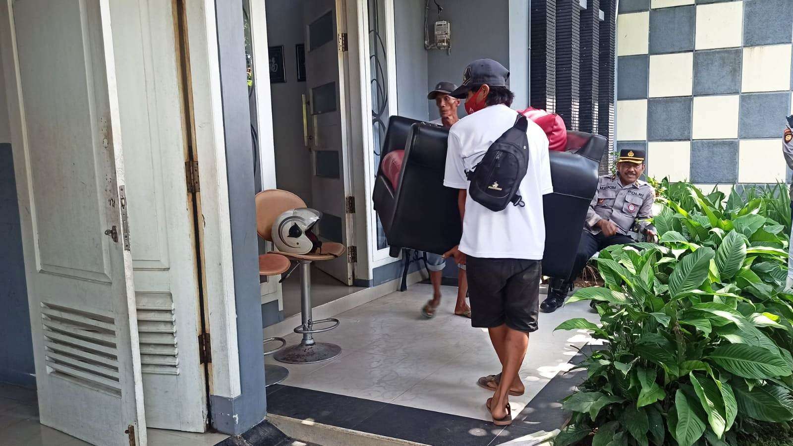 Sejumlah pekerja mengeluarkan perabotan dari rumah yang dieksekusi. (Foto: Muh Hujaini/Ngopibareng.id)