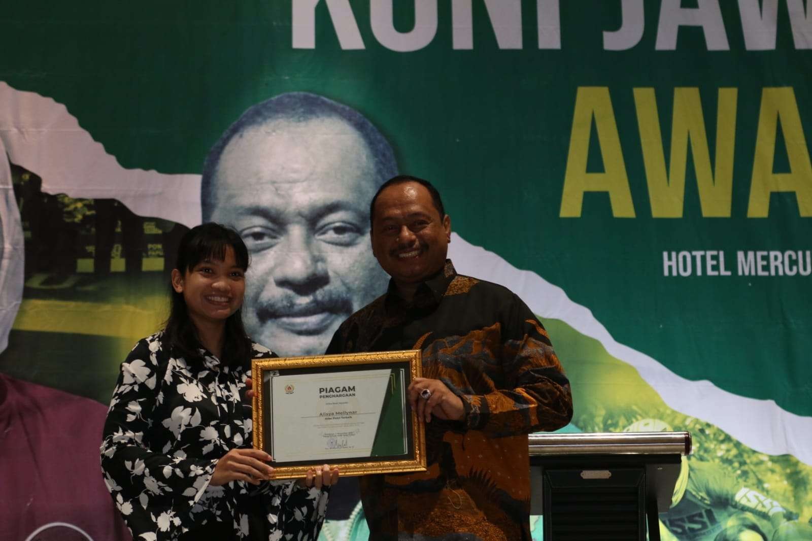 Ketua KONI Jatim M Nabil (kanan) memberi penghargaan kepada Atlet Putri Terbaik Alisya Mellynar dalam KONI Jatim Award 2022 di Hotel Mercure, Surabaya, Jumat 4 November 2022 malam. (Foto: Fariz Yarbo/Ngopibareng.id)