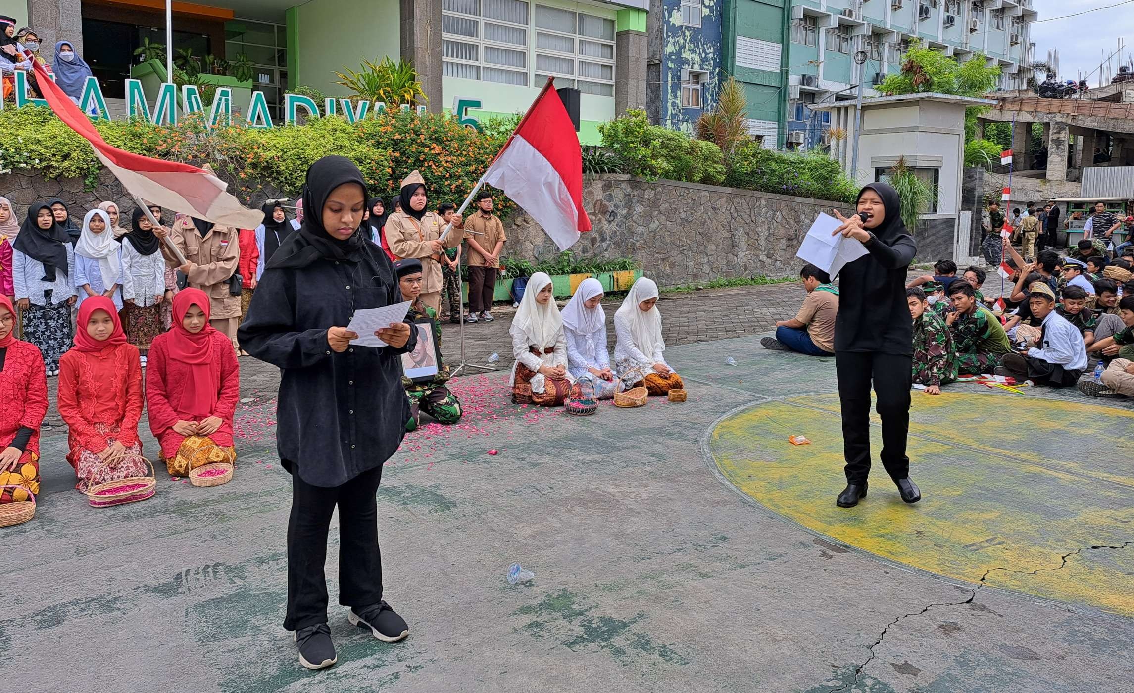 Riska dan Fatima Kayla, siswa SMP Muhammadiyah 5 Surabaya melakukan teatrikal peringati 10 November. (Foto: Pita Sari/Ngopibareng.id)