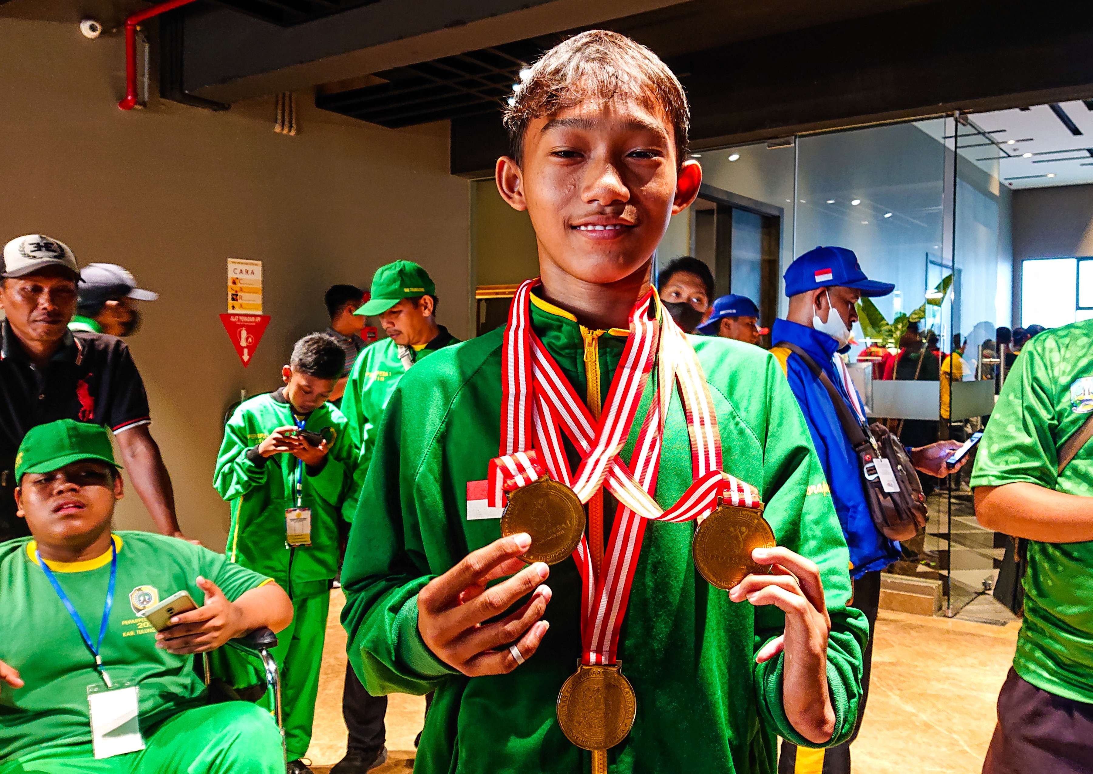 Ubaidilah, atlet paralympic renang, bangga menunjukan 3 medali emas. (foto : Aini/Ngopibareng.id)