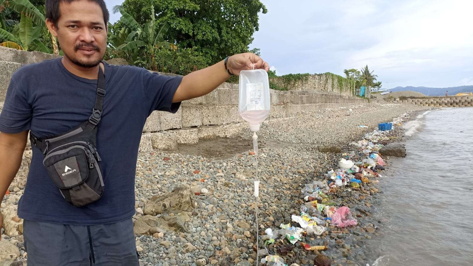 Ario Tri Yudha relawan Ekspedisi Sungai Nusantara, memungut limbah medis di Pantai Tawiri Kota Ambon, Kamis sore, 17 November 2022. (Foto: Ecoton)