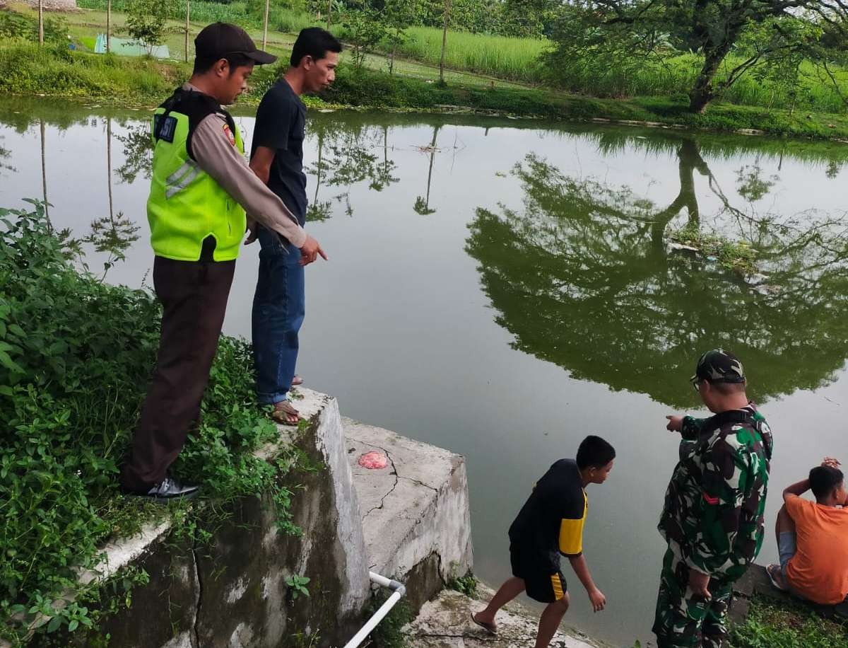 Anggota polisi dan TNI saat di lokasi kejadian korban tenggelam di waduk Dusun Sempur, Desa Sumbersari, Kecamatan Sambeng, Lamongan. (Foto: Istimewa)