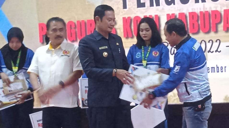 Bupati Lamongan Yuhronur Efendi didampingi Ketum KONI Lamongan Hery Pranoto menyerahkan bonus atlet. (Foto: Imron Rosidi/Ngopibareng.id)