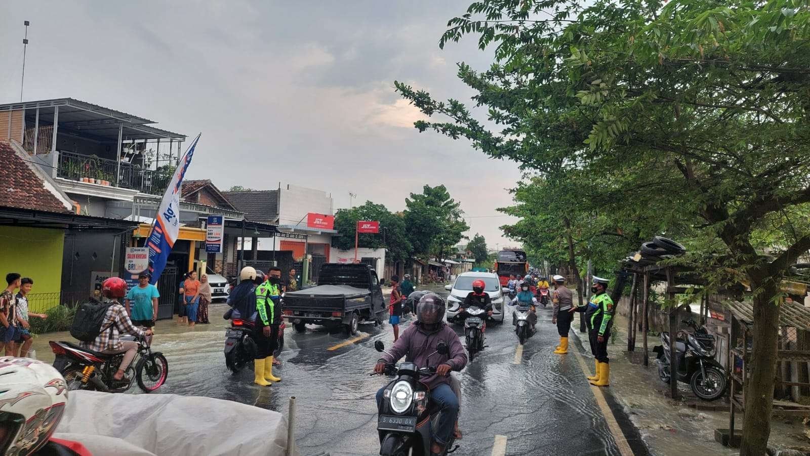 Jalan nasional Bojonegoro-Surabaya tepatnya di Desa Kabunan yang dilanda banjir akibat meluapnya Sungai Pacal, mengakibatkan lalu lintas terganggu, Sabtu 26 November 2022. (Foto: dok Polres Bojonegoro)