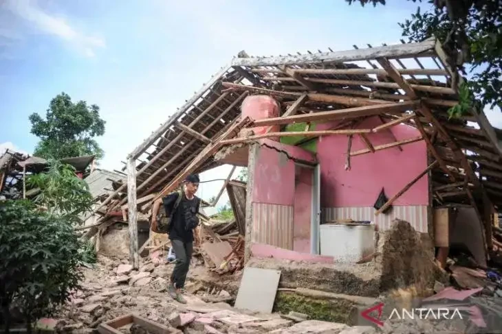 Warga melintas di depan rumah yang rusak akibat gempa di Kampung Selakawung Tengah, Kabupaten Cianjur, Jawa Barat, Selasa 22 November 2022. (Foto: Antara)