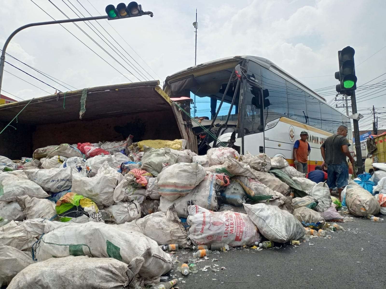 Barang bekas muatan truk yang ditabrak bus harapan Jaya berceceran di jalan.(Foto: Deni Lukmantara/Ngopibareng)