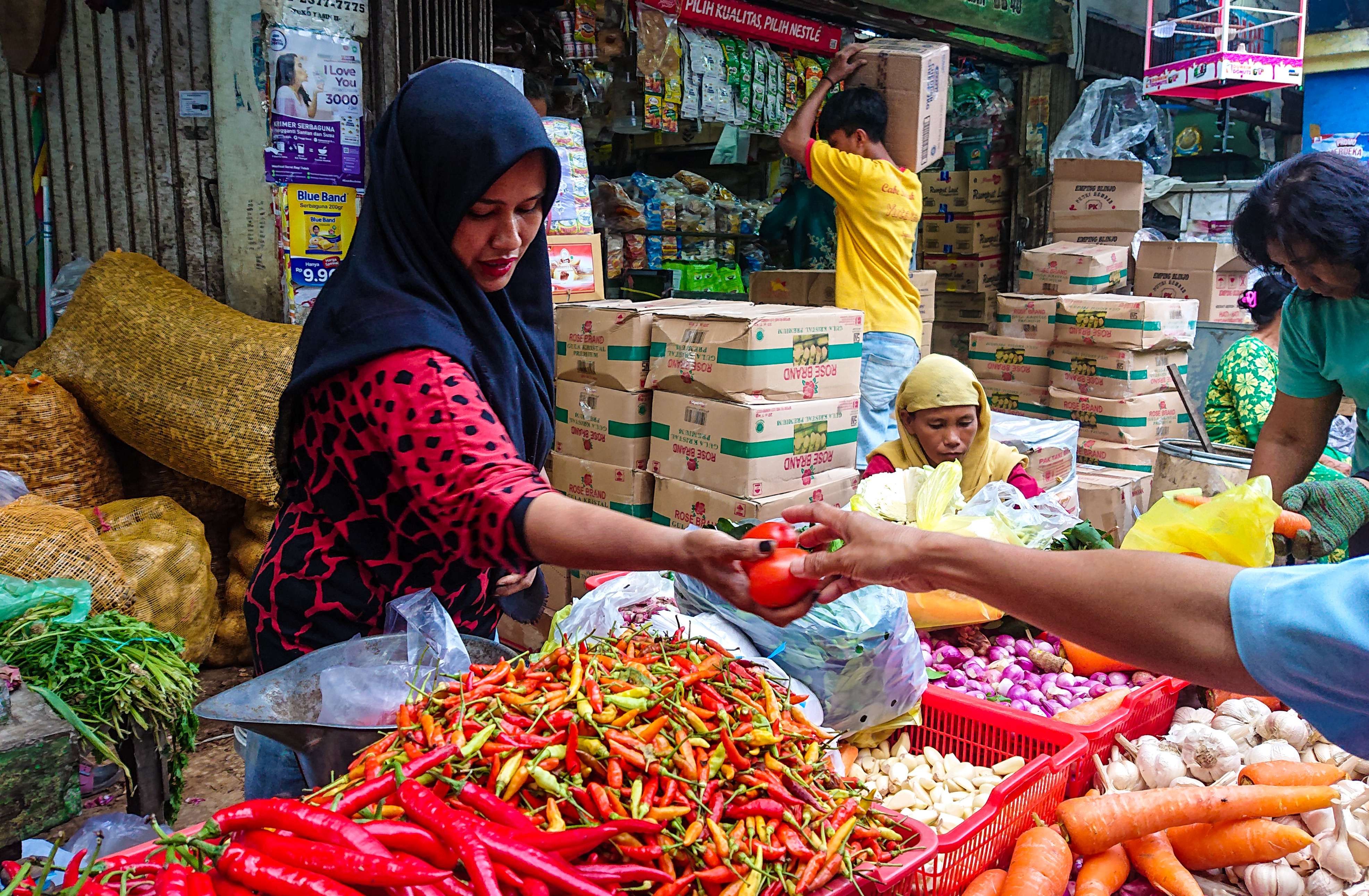 Nurhayati saat melayani pembeli tomat (foto: Aini/Ngopibareng.id)
