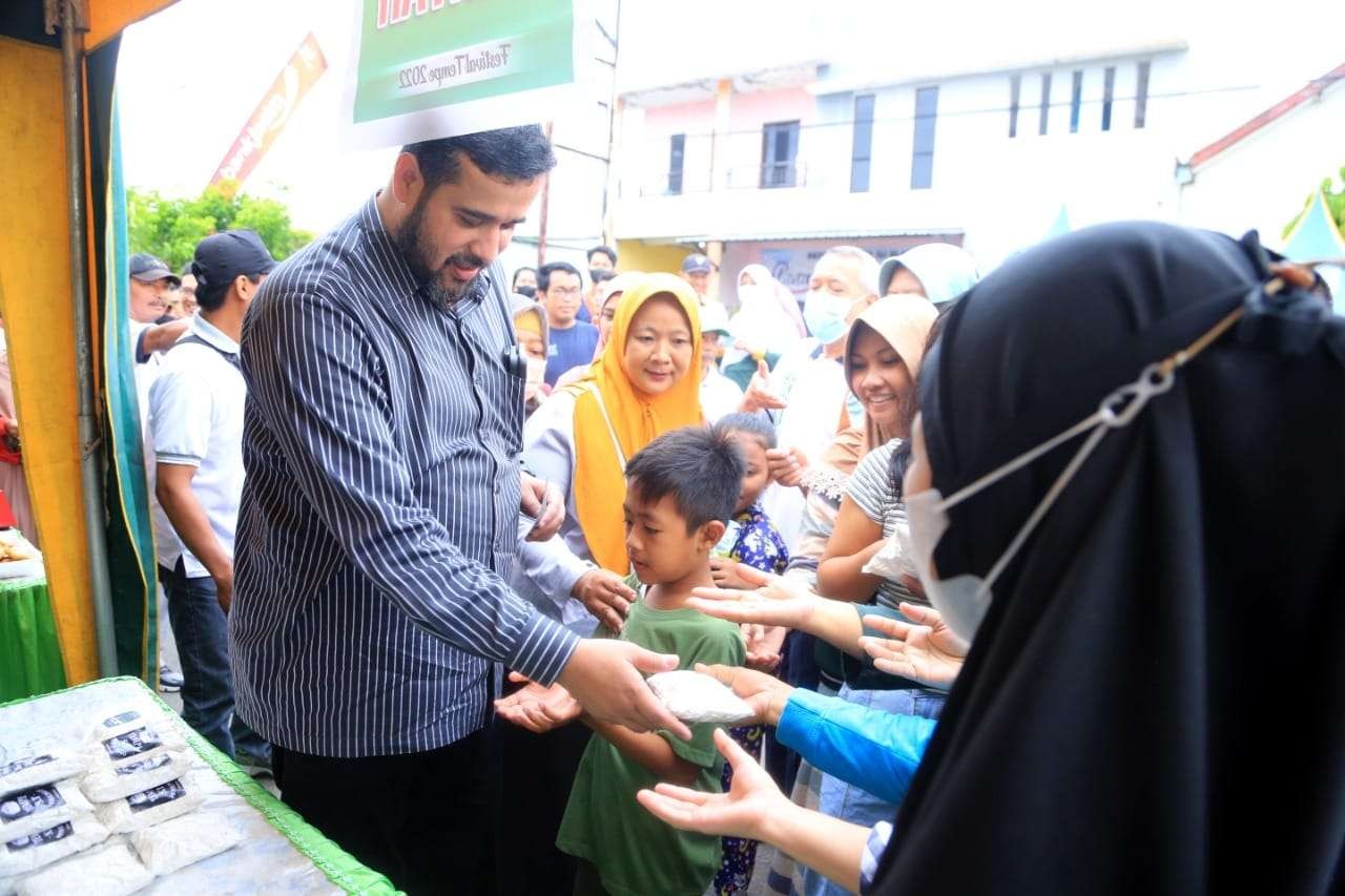Walikota Habib Hadi Zainal Abidin memotong dan membagikan tempe saat Festival Tempe di Sumbertanaman. (Foto: Ikhsan Mahmudi/Ngopibareng.id)