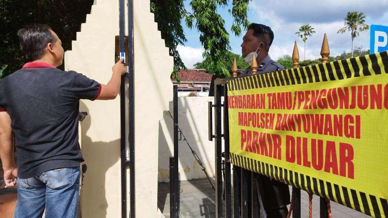Petugas Polsek Banyuwangi menunjukkan bel yang dipasang di pintu gerbang Polsek. (Foto: Muh Hujaini/Ngopibareng.id)
