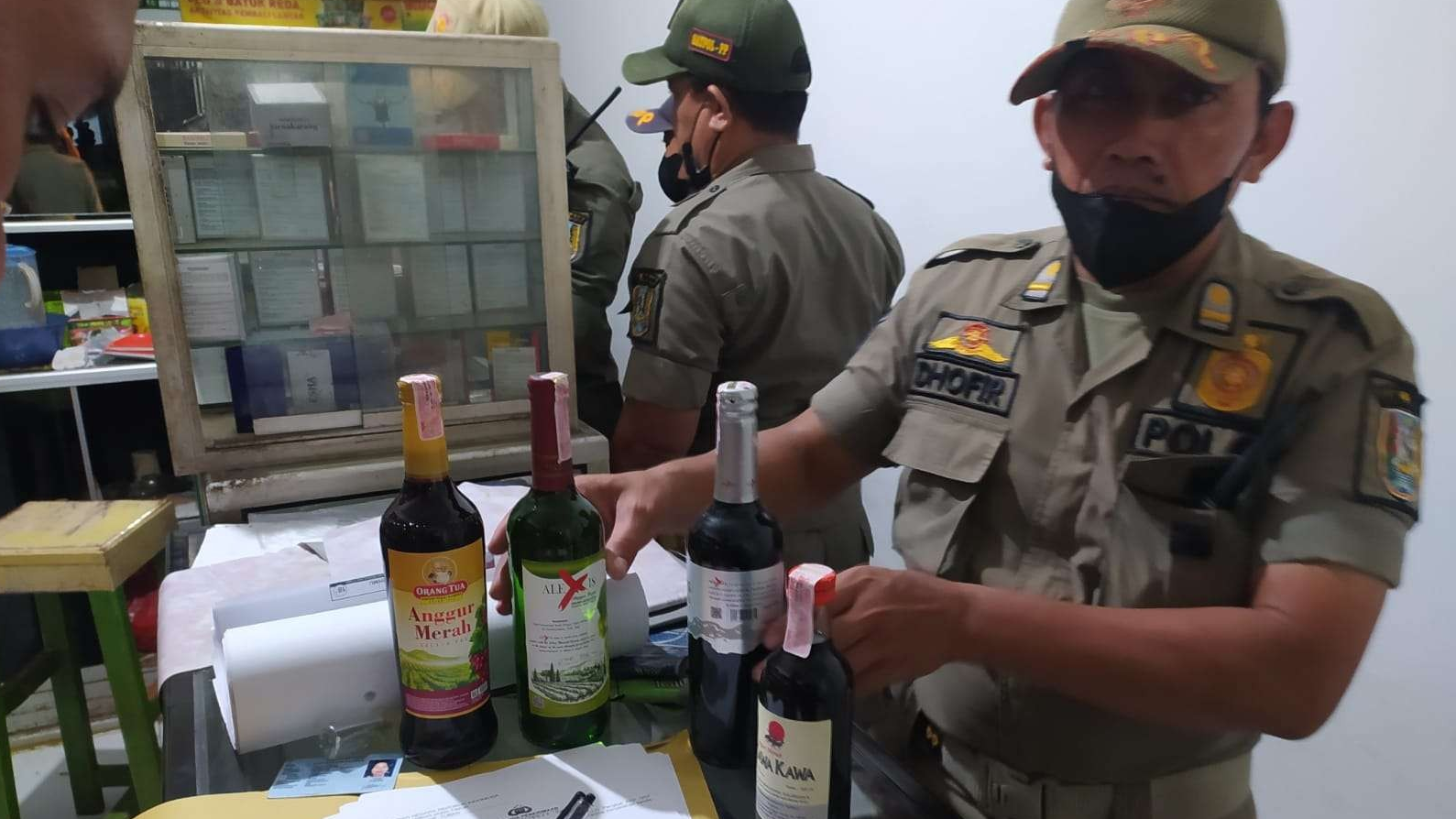 Petugas gabungan menunjukkan barang bukti minuman keras hasil razia (dok. Satpol PP Tuban)