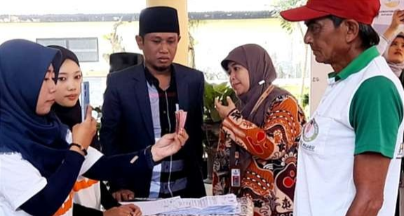 Kepala Dinsos P3AKB Bondowoso Anisatul Hamidah dan anggota DPR RI Fadil Muzakki meninjau penyaluran bansos di Bondowoso.(Foto: Guido Saphan/Ngopibareng.id)
