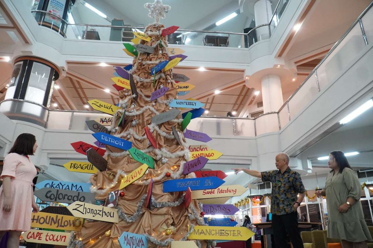 Pohon Natal bertema dunia yang ada di perpustakaan UK Petra Surabaya. (Foto: Pita Sari/Ngopibareng.id)