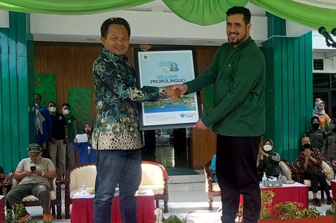 Walikota Habib Hadi Zainal Abidin (kanan) menerima penghargaan dari Head of Climate & Market Transformation WWF Indonesia, Joko Sarjito. (Foto: Ikhsan Mahmudi/Ngopibareng.id)