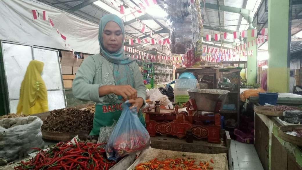Salah satu pedagang di Pasar Baru Tuban sedang melayani pembeli cabai (Foto: Khoirul Huda/Ngopibareng.id)
