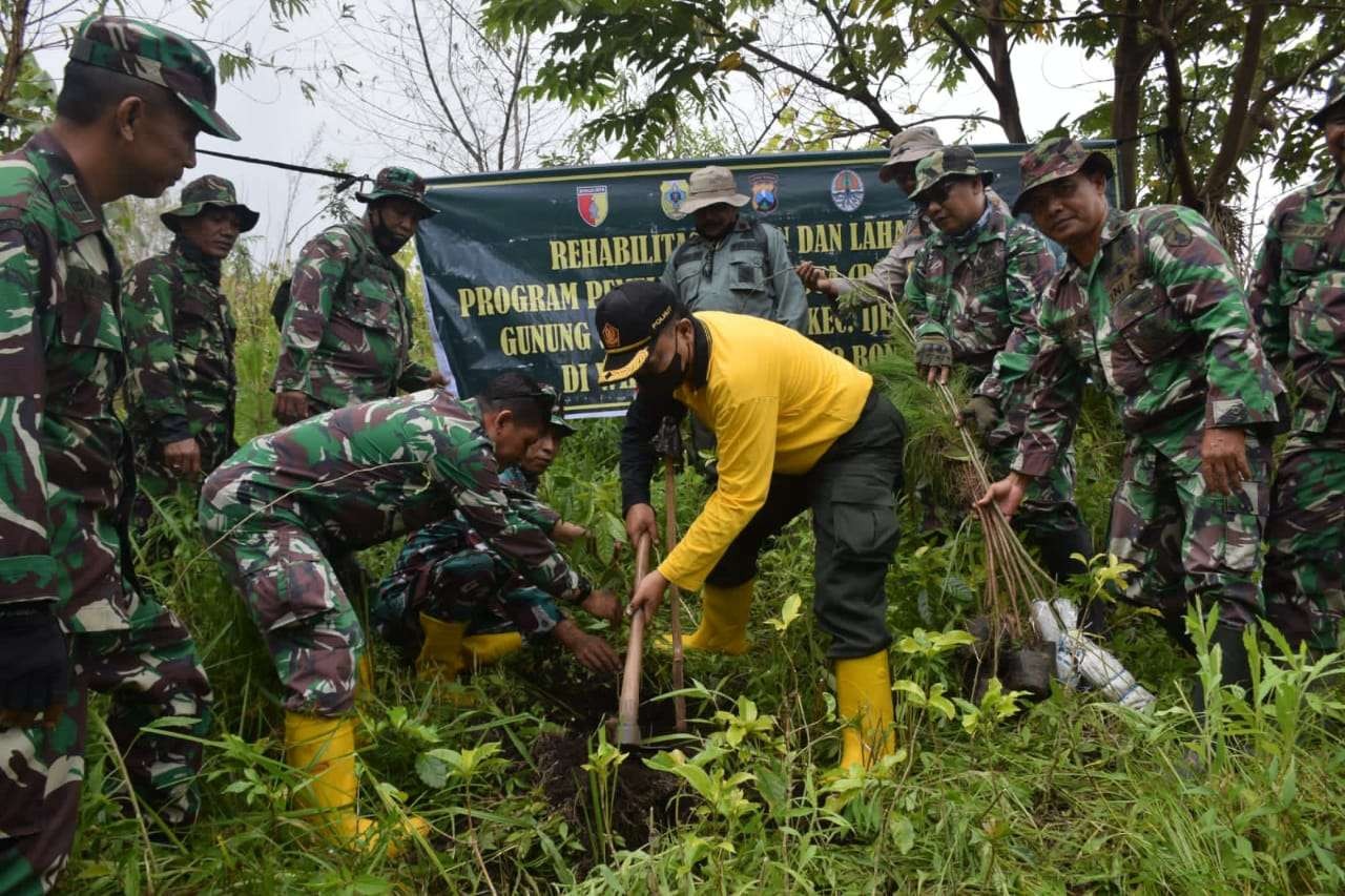 ADM Perhutani Bondowoso Andi Andrian Hidayat bersama anggota TNI Kodim 0822 Bondowoso menanam ribuan bibit pohon di lereng Gunung Suket Ijen Bondowoso. (Foto: Guido Saphan/ngopibareng.id)