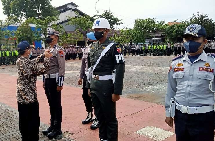Sekda Tuban saat menyematkan pita kepada perwakilan personel saat apel gelar pasukan Operasi Lilin Semeru 2022 (Khoirul Huda/Ngopibareng.id)