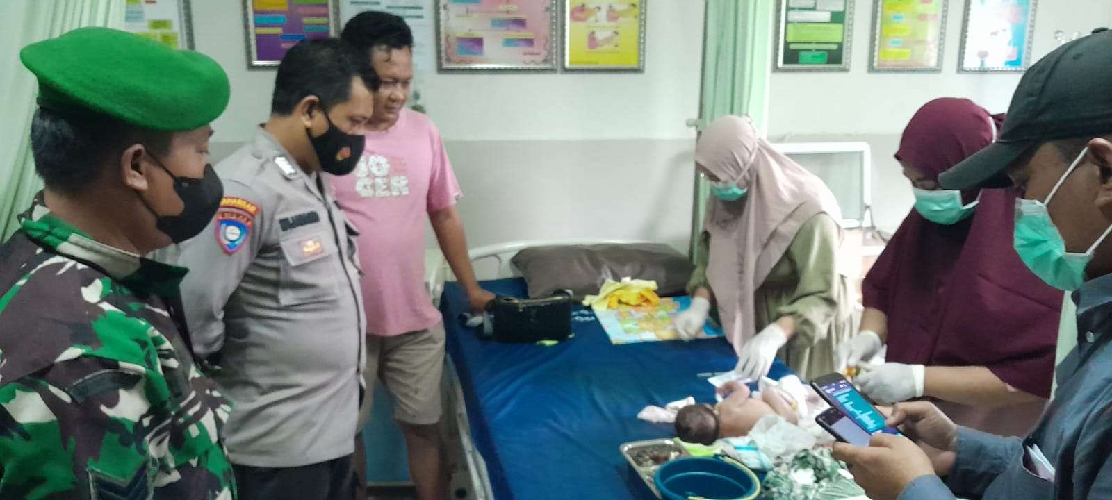 Petugas Polsek dan Koramil Mantup dan tenaga medis Puskesmas setempat sedang melihat kondisi bayi (Foto: Istimewa)