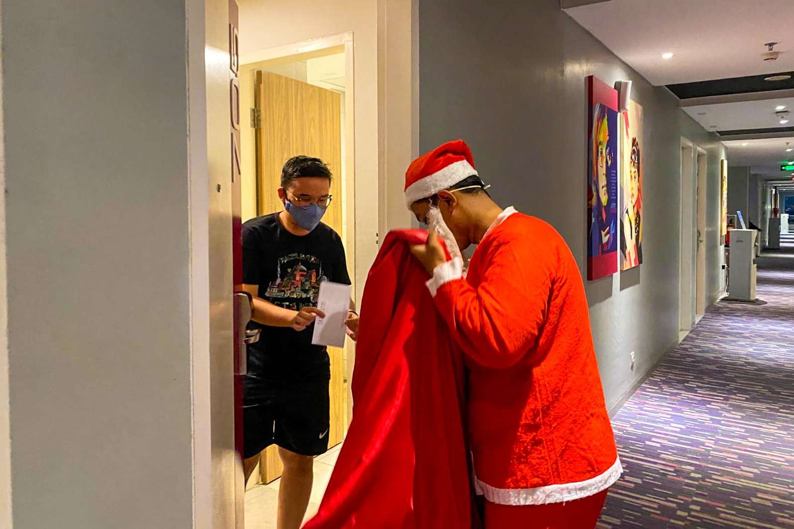 Santa claus saat bagi-bagi hadiah natal ke tamu hotel di Sidoarjo. (Foto: Aini Arifin/Ngopibareng.id)