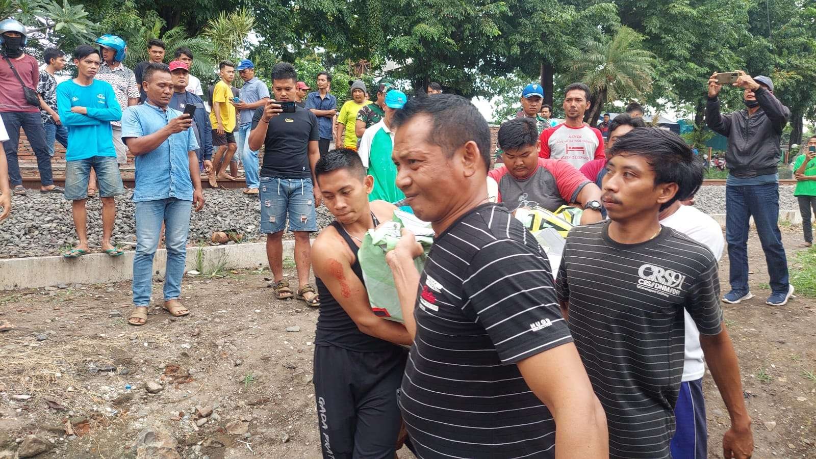 Warga mengevakuasi jenazah anggota TNI dan dua anaknya yang tewas tertabrak KA di Probolinggo. (Foto: Ikhsan Mahmudi/Ngopibareng.id)