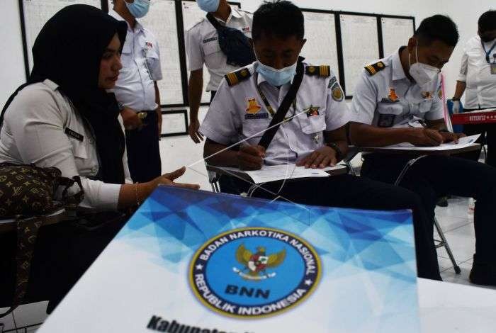 Petugas Badan Narkotika Nasional (BNN) menyerahkan wadah sampel urine saat pemeriksaan narkoba kepada masinis serta petugas operasional Kereta Api (KA) di Madiun, Jawa Timur, Senin 26 Desember 2022.(Foto: Antara)
