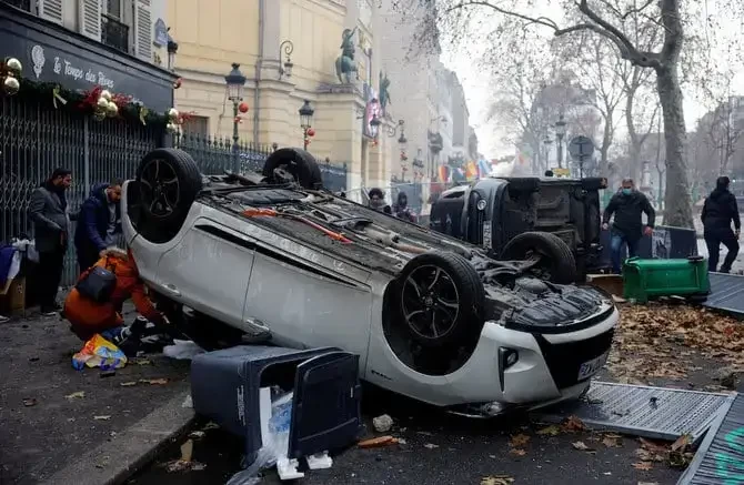Bentrokan berlanjut selama sekitar dua jam sebelum pengunjuk rasa bubar. Orang-orang melihat kendaraan yang terbalik saat anggota komunitas Kurdi menghadiri demonstrasi menyusul penembakan di Paris 24 Desember 2022. (Reuters)