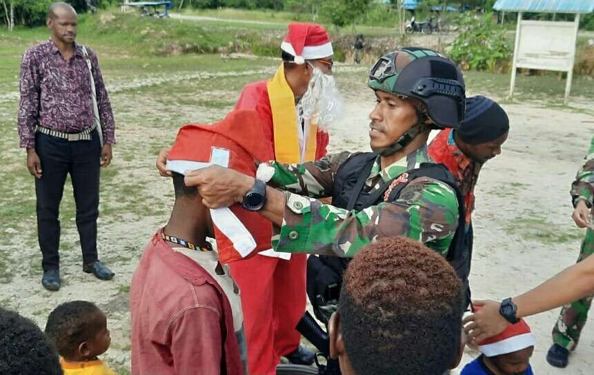 Prajurit TNI Satgas Yonif Raider 514/SY Kostrad Bondowoso berbagi kado Natal kepada anak-anak Kenyam Nduga Papua Pegunungan.(foto: penyonif R 514)