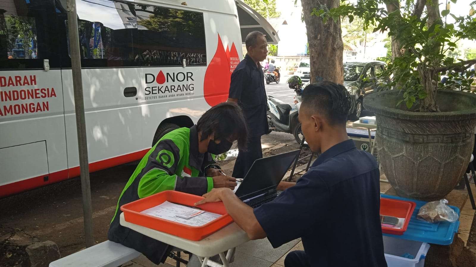 Seorang pekerja ojek online sedang mendaftar donor darah di mobil keliling PMI Lamongan. (Foto: Imron Rosidi /ngopibareng.id)