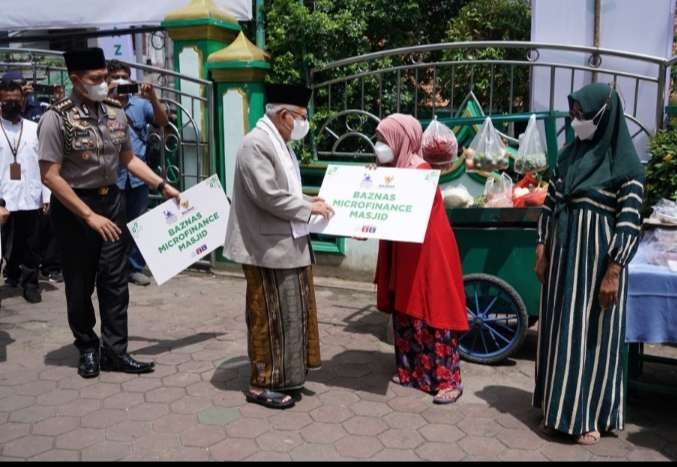 Wapres KH Ma'ruf Amn  menyerahkan bantuan kepada penerima manfaat di Masjid Raya Attaqwa ( foto': BPMI Setwapres)⁸