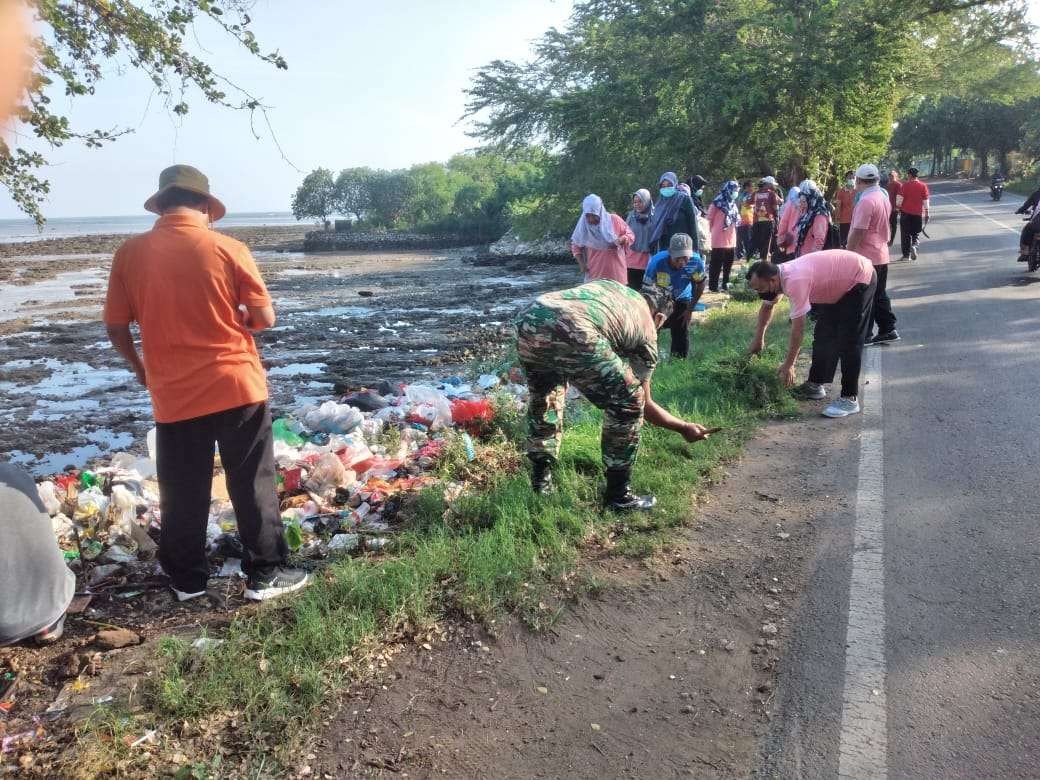 Kerja bakti Babinsa, perangkat desa dan masyarakat membersihkan sampah di jalan raya pantura Lamongan. (Foto: Istimewa)