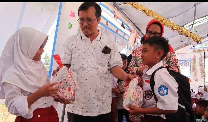 Ketua Wartawan Pendidikan  Syarif Ubaidillah secara simbolis menyerahkan bantuan peralatan sekolah kepada anak didik terdampak Gempa Cianjur (Foto: Asmanu Sudharso/Ngopibareng.id)