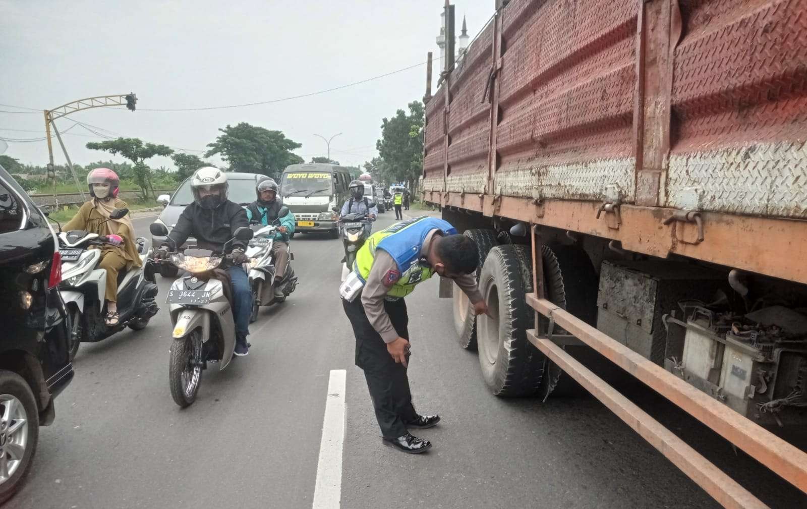 Petugas Satlantas Polres Lamongan menunjukkan posisi korban saat dilindas truk tronton. (Foto: Imron Rosidi/Ngopibareng.id)