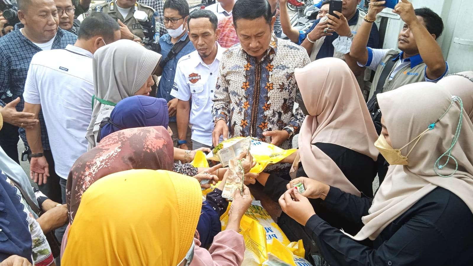 Bupati. lamongan, Yuhronur Efendi saat ikut melayani OPM beras di Pasar Sidoharjo, Lamongan (Foto: Imron Rosidi/ngopibareng.id)