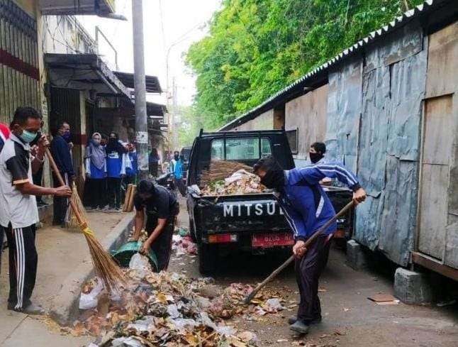 Petugas kebersihan membersihkan sampah di dekat Tempat Penampungan Sementara (TPS) pedagang Pasar Baru, Kota Probolinggo. (Foto: Ikhsan Mahmudi/Ngopibareng.id)