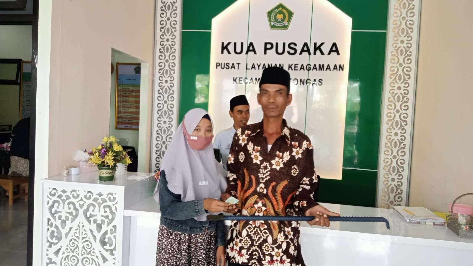 Samsul Mukmin bersama istrinya, Sumiati usai menikah di Kantor Urusan Agama (KUA) Tongas, Kabupaten Probolinggo. (Foto: Ikhsan Mahmudi/Ngopibareng.id)